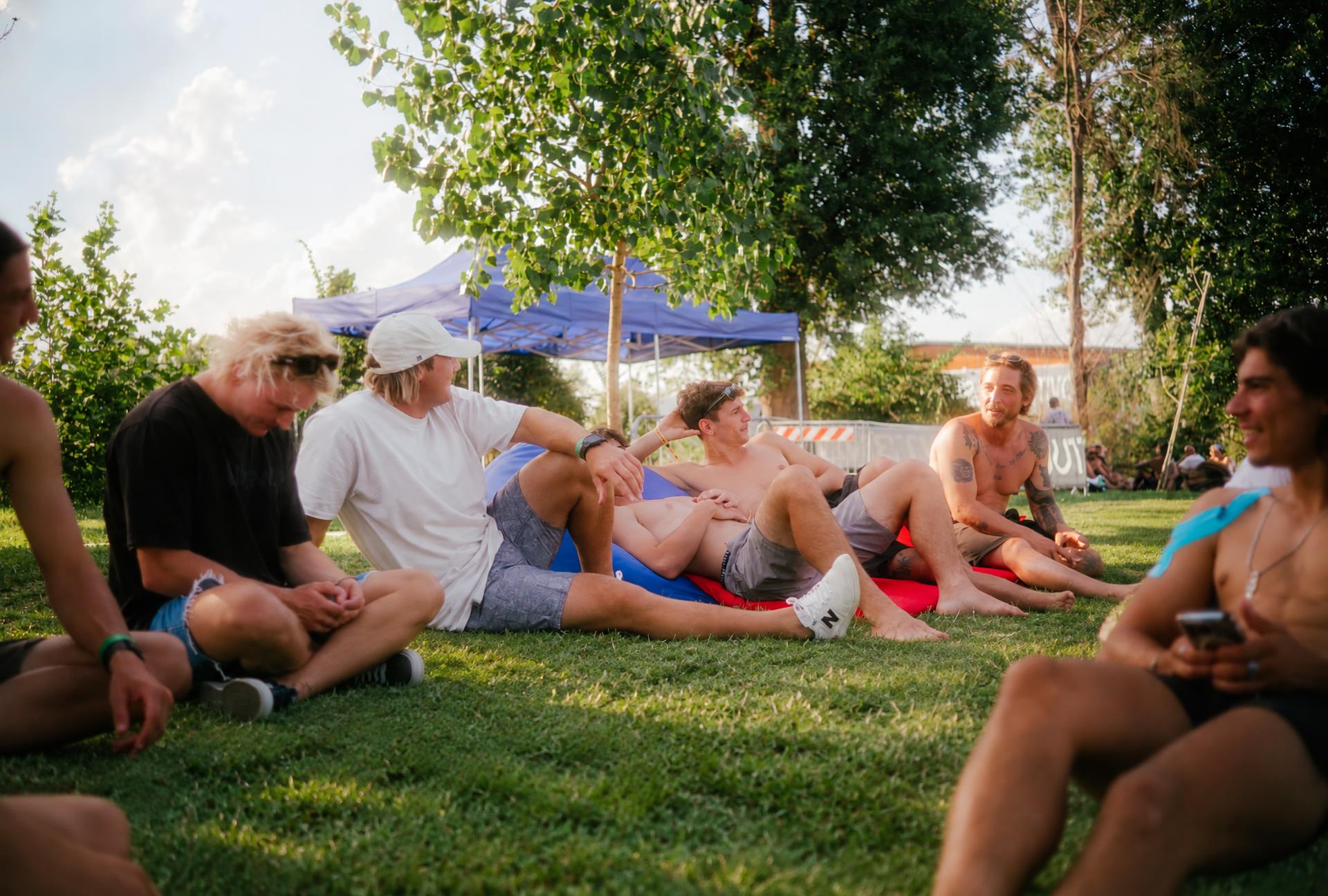Cable wake riders relaxing together on the grass between sessions